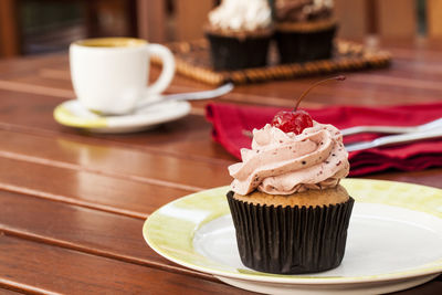 Coffee cup and cake on table