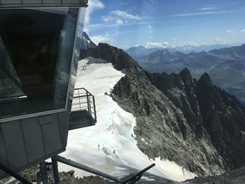 Overhead cable car over mountains against sky