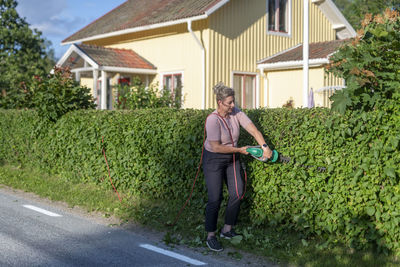 Woman pruning hedge