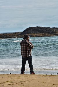 Full length of man standing on beach against sky