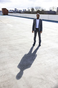 Businessman standing at terrace parking during sunny day