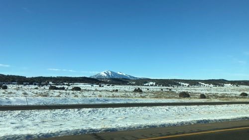 Scenic view of snowcapped mountains against clear blue sky