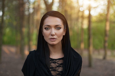 Portrait of beautiful young woman standing in forest