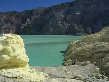 Rock formations by sea against sky