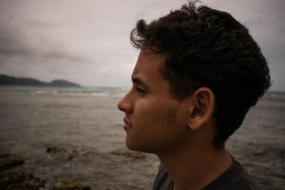 Close-up of mid adult man at beach against sky