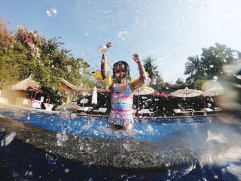 Girl splashing water in swimming pool