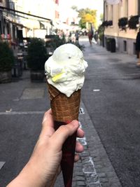 Woman holding ice cream cone on street