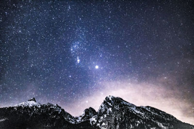 Scenic view of snowcapped mountains against sky at night