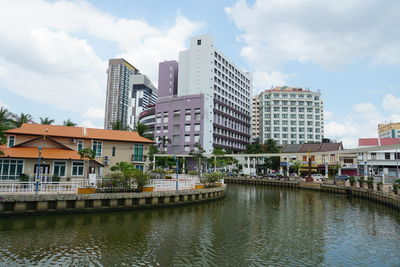 River by buildings against sky in city