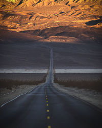 Empty road leading towards mountain