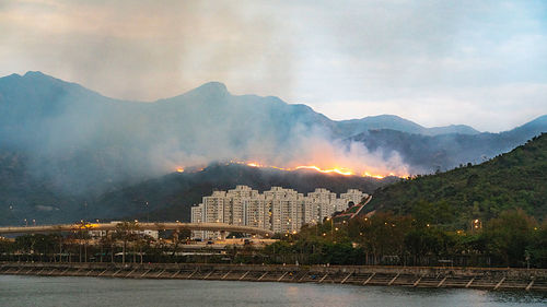Scenic view of buildings and mountains against sky
