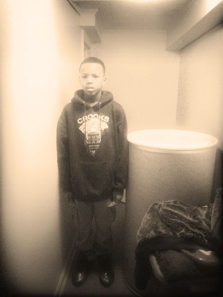 PORTRAIT OF YOUNG MAN STANDING ON WALL