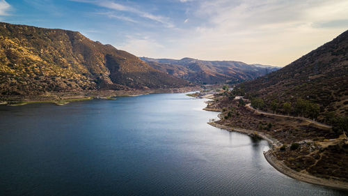 Scenic view of lake by mountains against sky