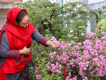  view of a woman standing by flowering plants