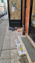 Man sitting on sidewalk in city