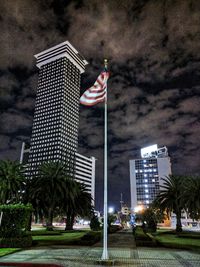 Low angle view of flag against cloudy sky at night