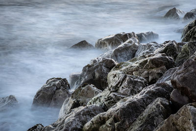 Scenic view of rocky beach against sky