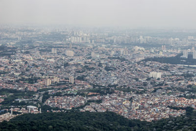 Aerial view of cityscape against sky during foggy weather