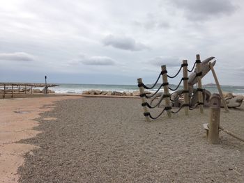 Scenic view of beach against cloudy sky