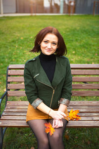 Portrait of a smiling young woman sitting on bench