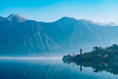 Scenic view of lake by mountain against sky