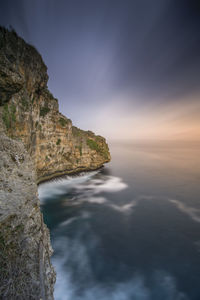 Rock formations by sea against sky