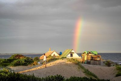 Scenic view of rainbow over sea against sky