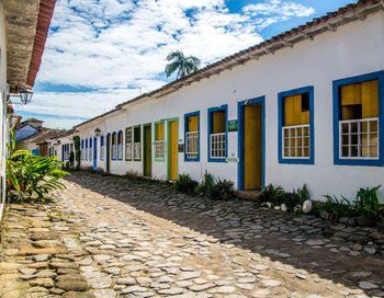 Houses by street against sky in city