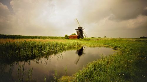 Traditional windmill on field against sky