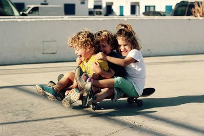 Kids playing skateboard on playground in summer