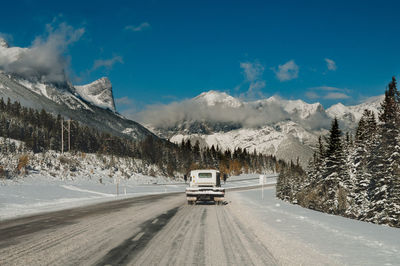 Road amidst snowcapped mountains against sky