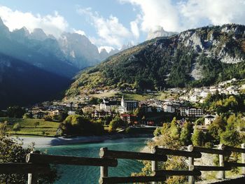 Scenic view of townscape by mountains against sky