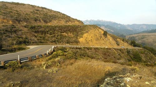 Scenic golden autumn view of road through mountains against sky