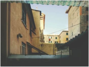 Houses against sky seen through balcony