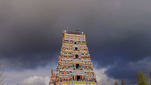 Low angle view of illuminated tower against cloudy sky