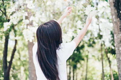 Rear view of woman standing by plants