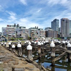 Buildings by river against sky in city