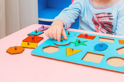 Low angle view of girl playing with toy on table