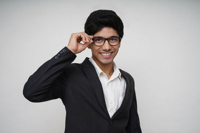 Portrait of smiling young man against white background