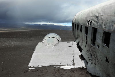 Abandoned airplane on land against sky