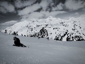 Rear view of woman on snowcapped mountain against sky