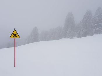 Road sign on snow covered land