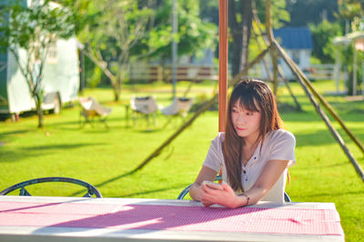 Young woman using laptop at park