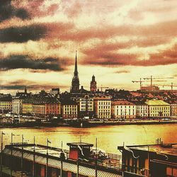 Cityscape against cloudy sky at sunset