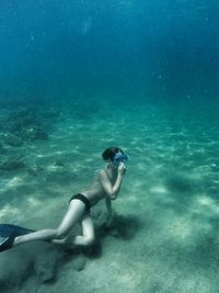 Full length of shirtless boy swimming undersea