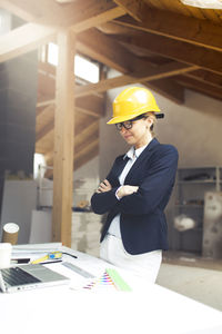 Architect wearing hardhat while working at construction site