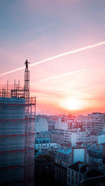 Buildings in city against sky during sunset