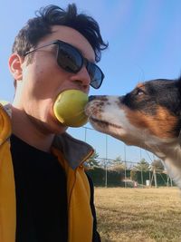 Midsection of man with dog against sky