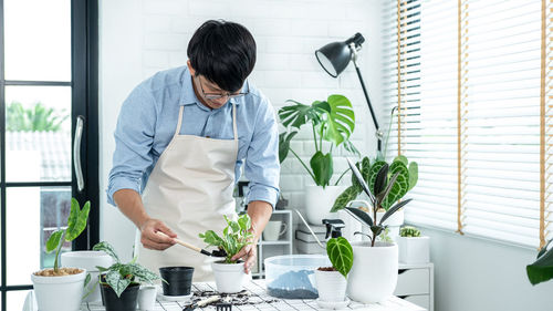 Man standing by potted plant on table