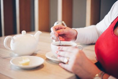 Cropped image of woman having coffee in cafe